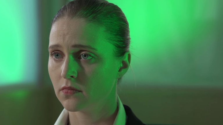 Still from indie short film Cynthetic. Close-up of Jenna Hill's face bathed in a green light.